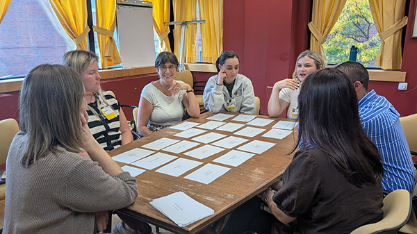 students arounds a table engaging in an index card activity