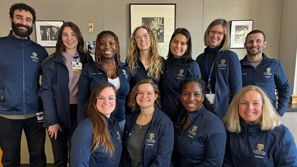 group of interns wearing blue University of Rochester jackets