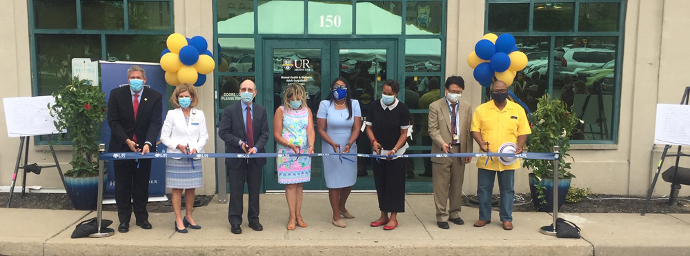 group of medical staff at ribbon cutting in front of outpatient clinic