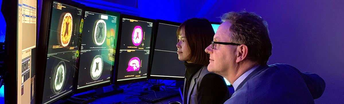 2 researchers looking at brain scans