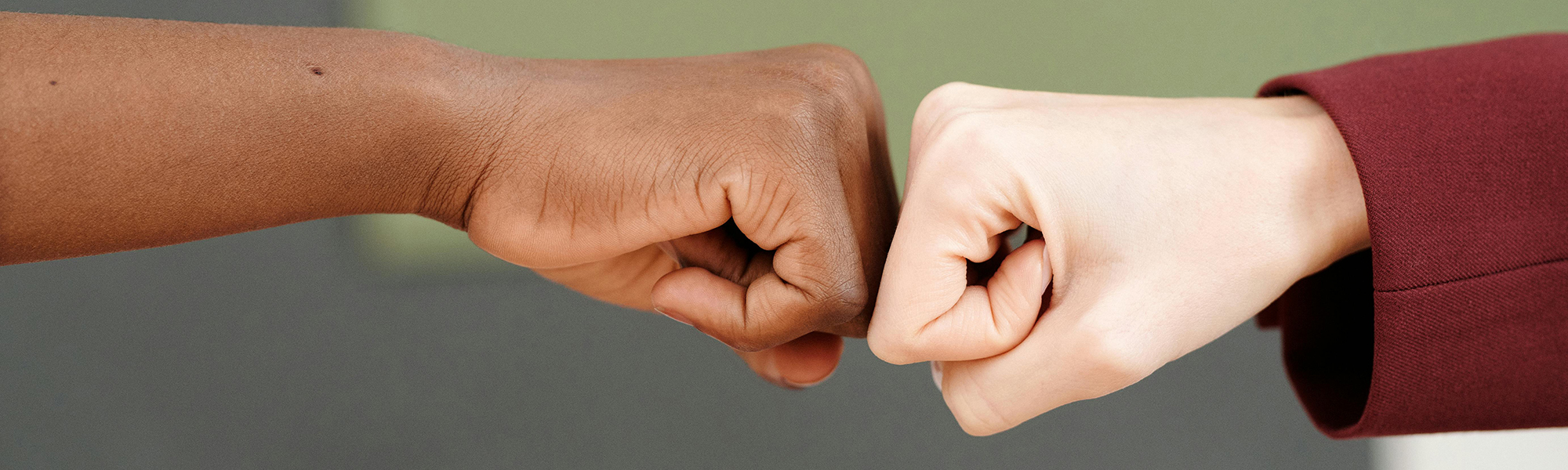 caucasian and african american hands fist bumping