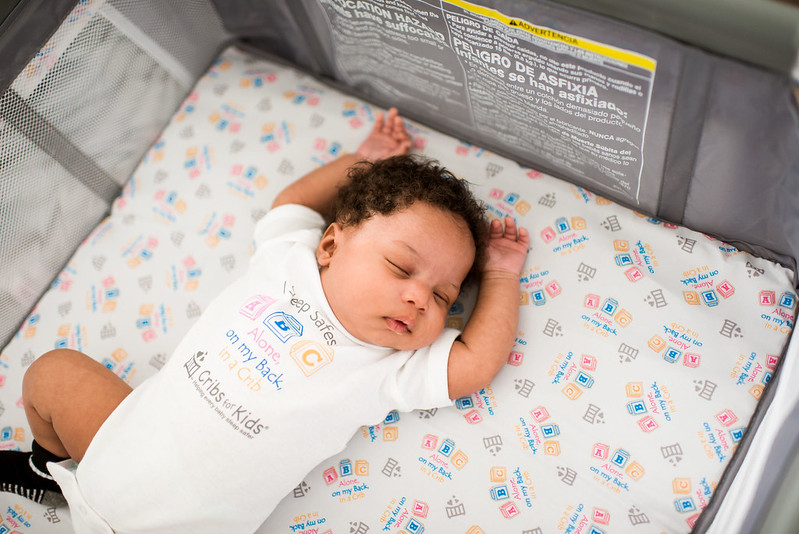 Baby sleeping on his back in crib.