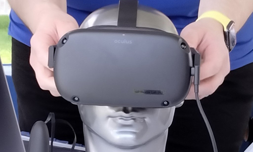 Person placing a VR headset on a manikin
