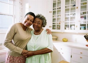 A middle-aged woman and an elderly woman hugging in a kitchen