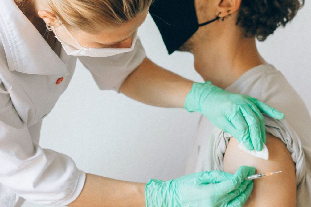 Female provider giving a young male the measles vaccine