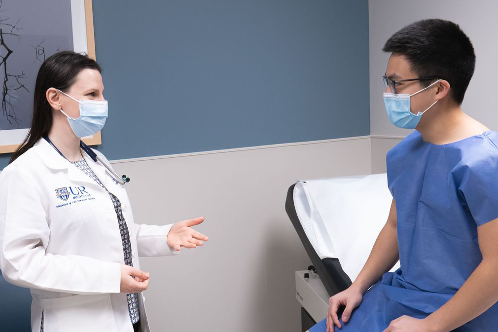 URochester Medicine provider talking with a patient sitting on a table in an exam room
