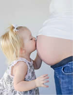 Little Girl Kissing Pregnant Belly