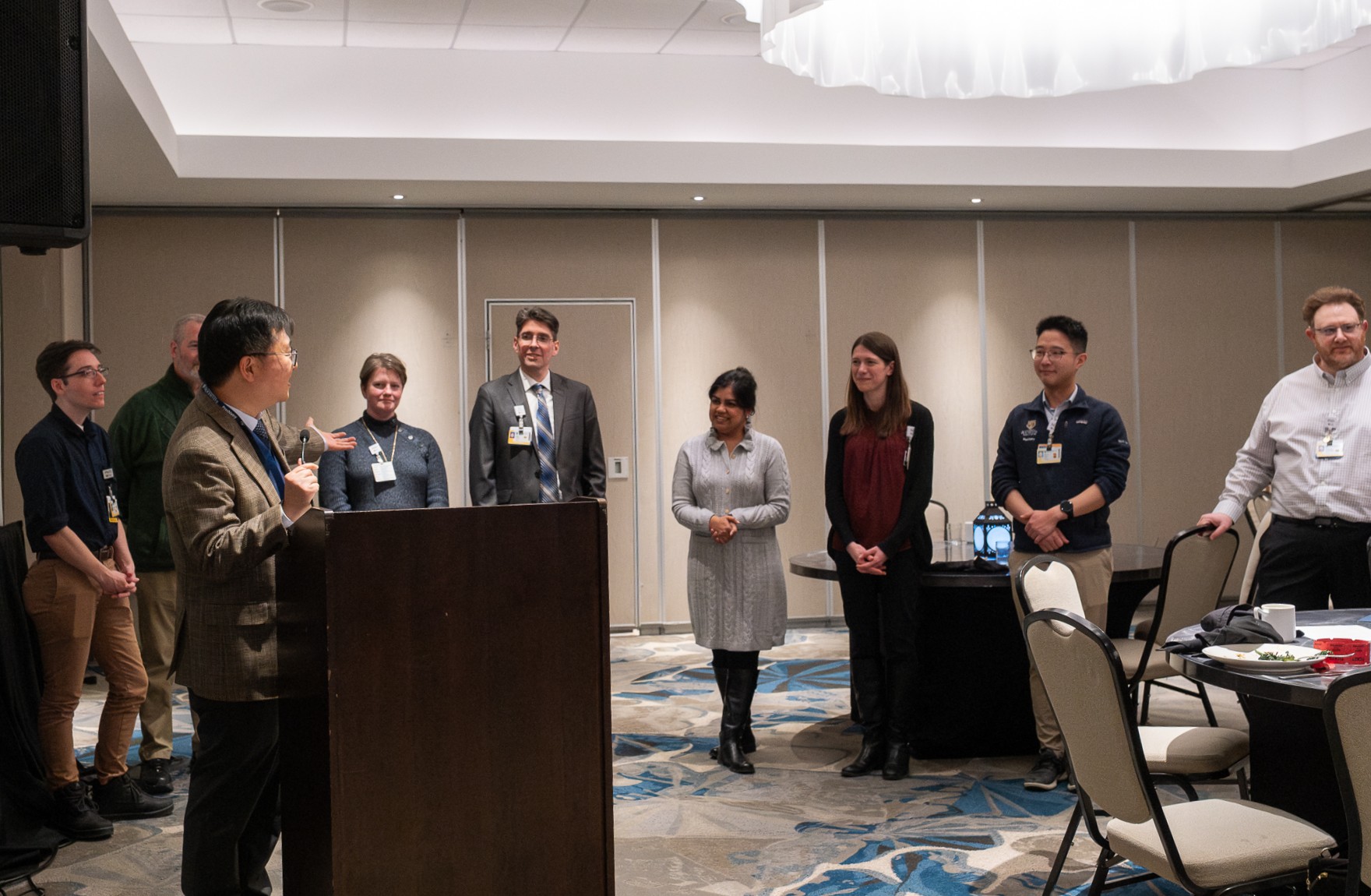 Image of Dr. Hochang Ben Lee presenting at a podium with Department of Psychiatry new faculty members