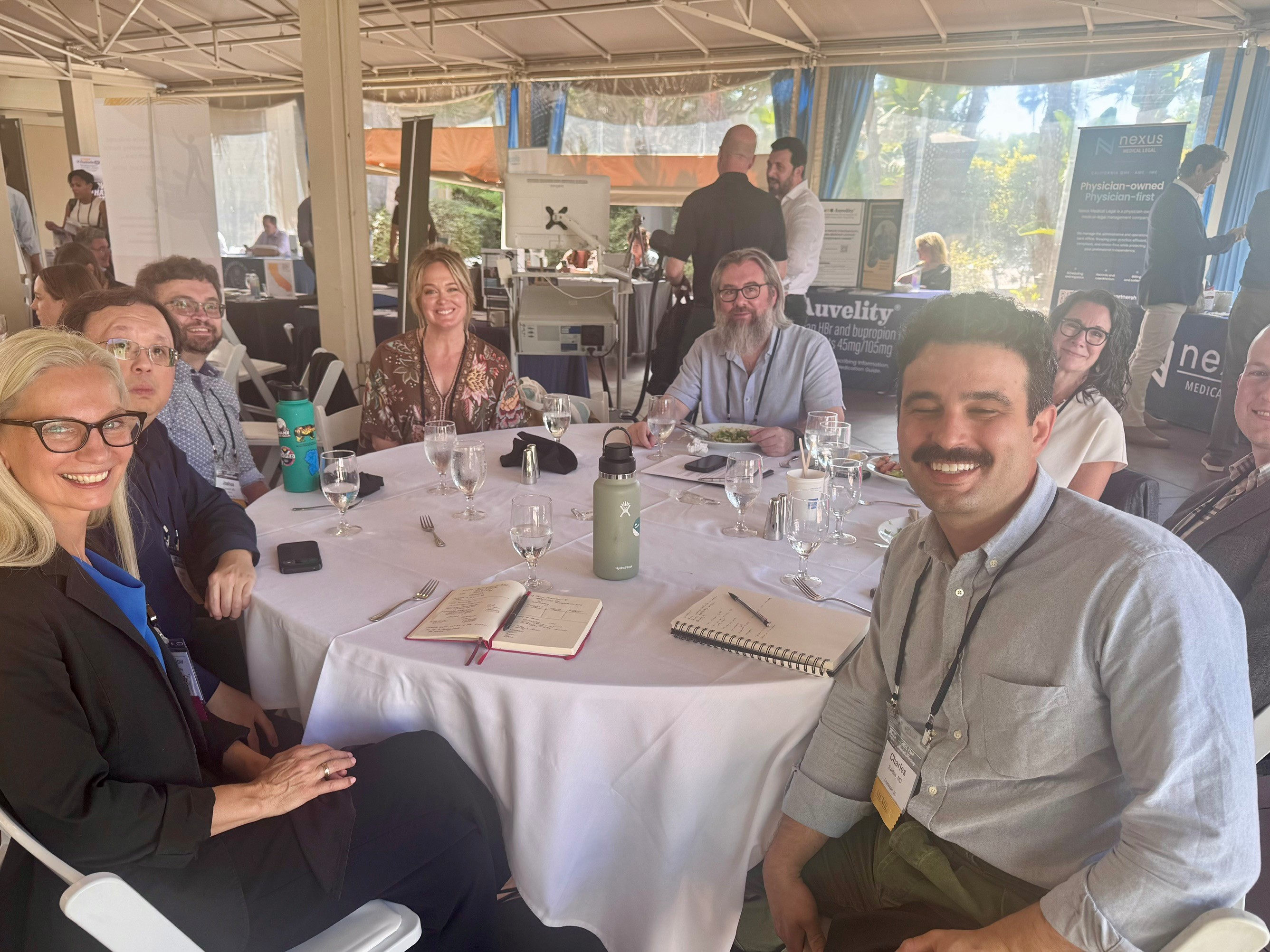 MIPS faculty sitting at a table at the Association of Medicine and Psychiatry's meeting