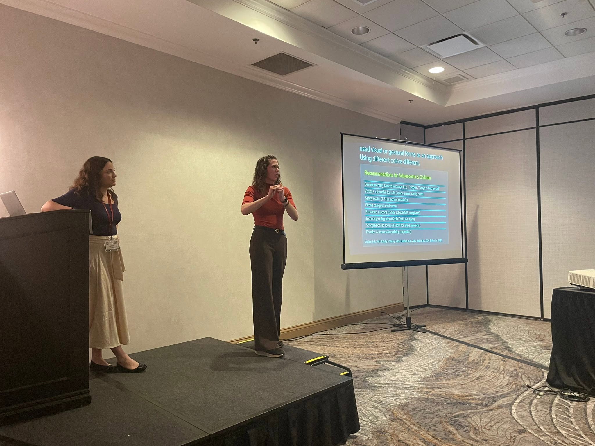 Deaf Wellness Center team at a podium and stage at the ADARA conference