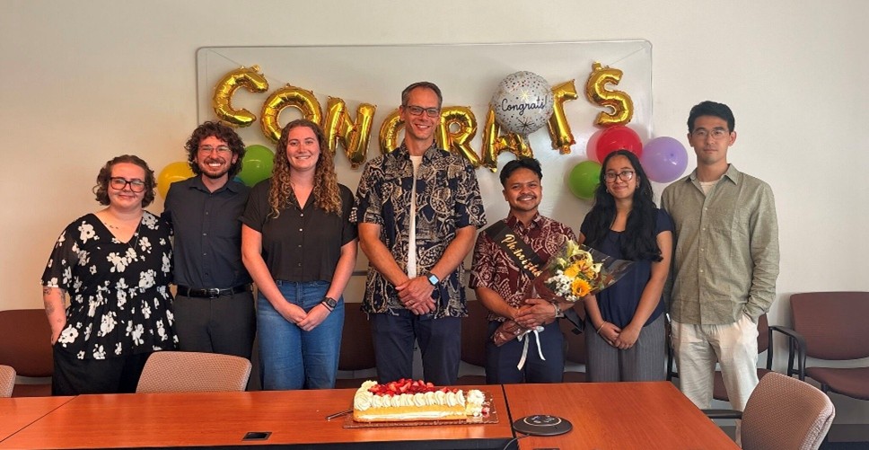 Group photo in front of congrats balloons