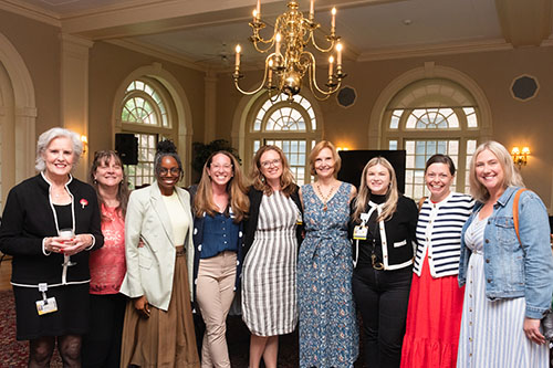 Photo of nine women standing and looking at the camera