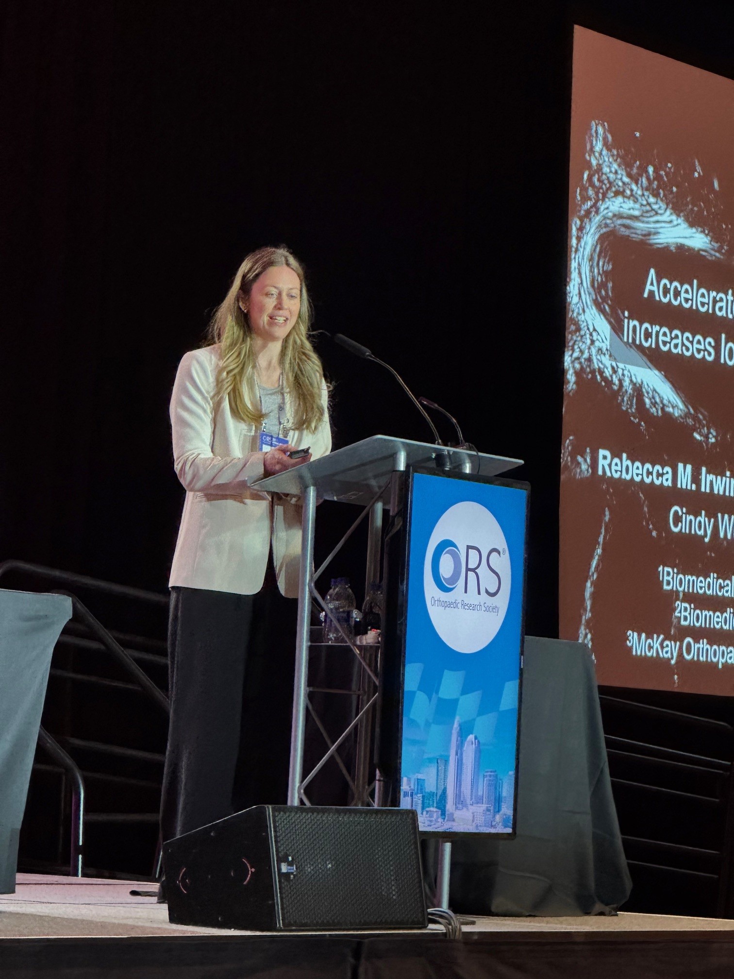 Professor Irwin presenting on a stage at a podium
