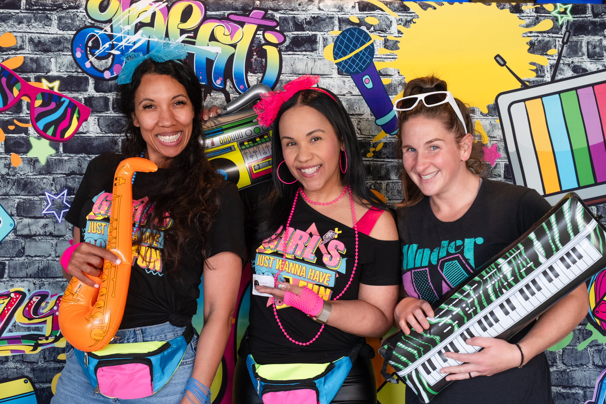 Photo of Psychiatry nurses posing in front of an 80's themed backdrop