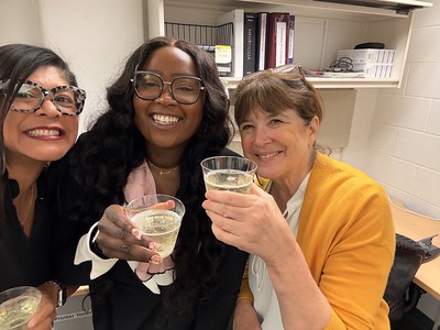 Emily, Julie, and Dennisha toasting with cocktail after dissertation