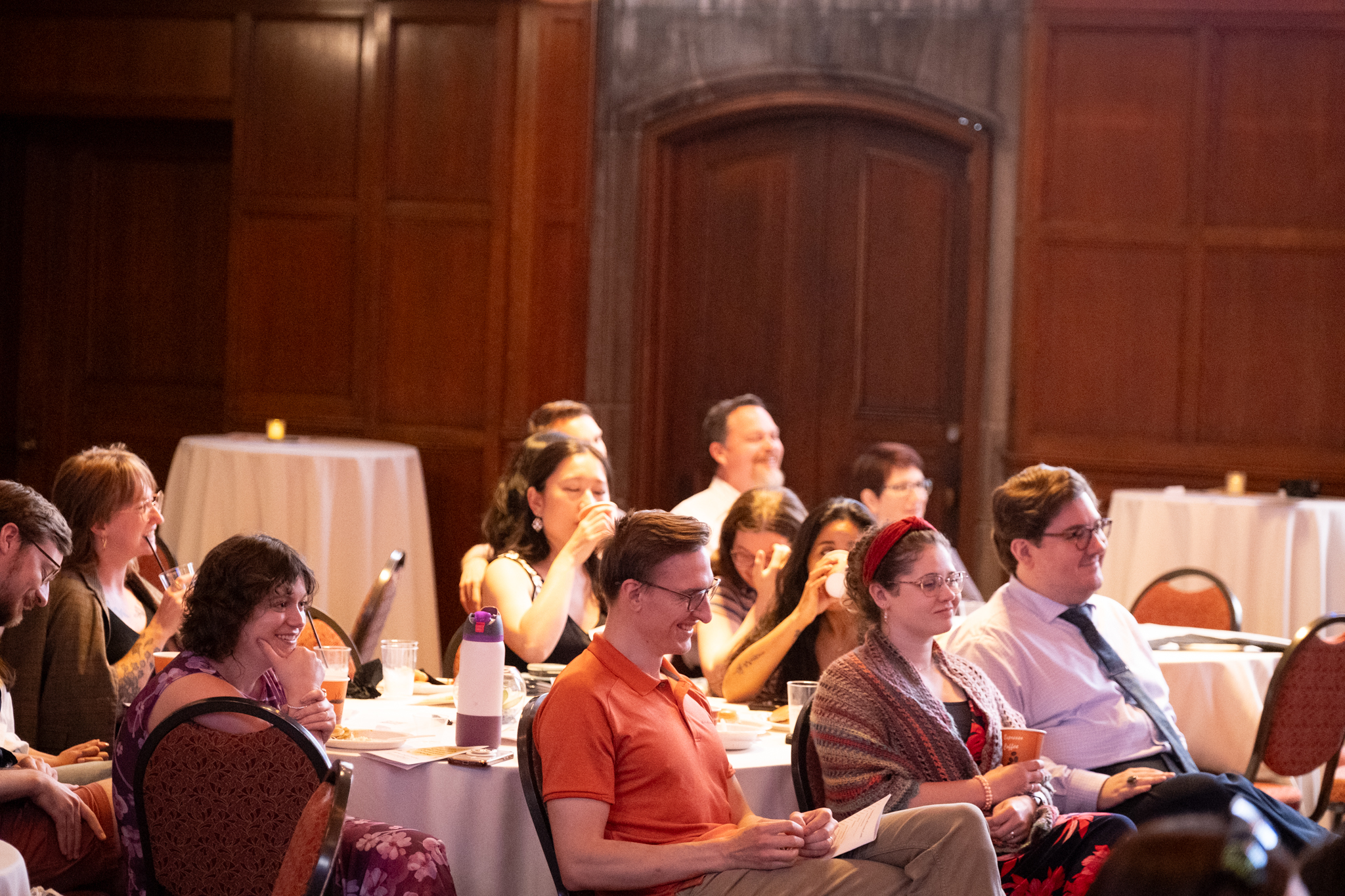 Photo of Psychiatry employees sitting in chairs in a ballroom laughing