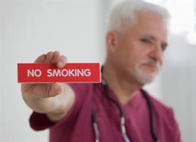 Image of No Smoking Sign in Man's Hand
